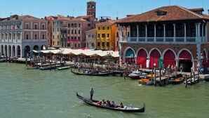 A canal with gondolas, historic buildings, and a clear sky. - Ca' Sagredo (Venice)
