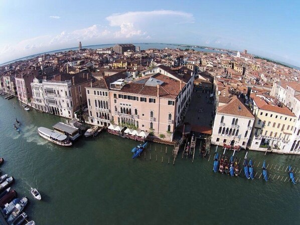 An aerial view of a historic city with a river, buildings, and boats.