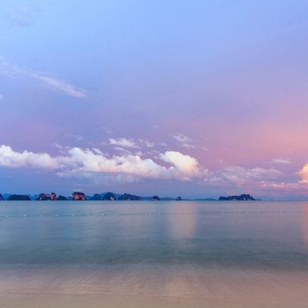 A calm sea with a clear sky and distant islands.