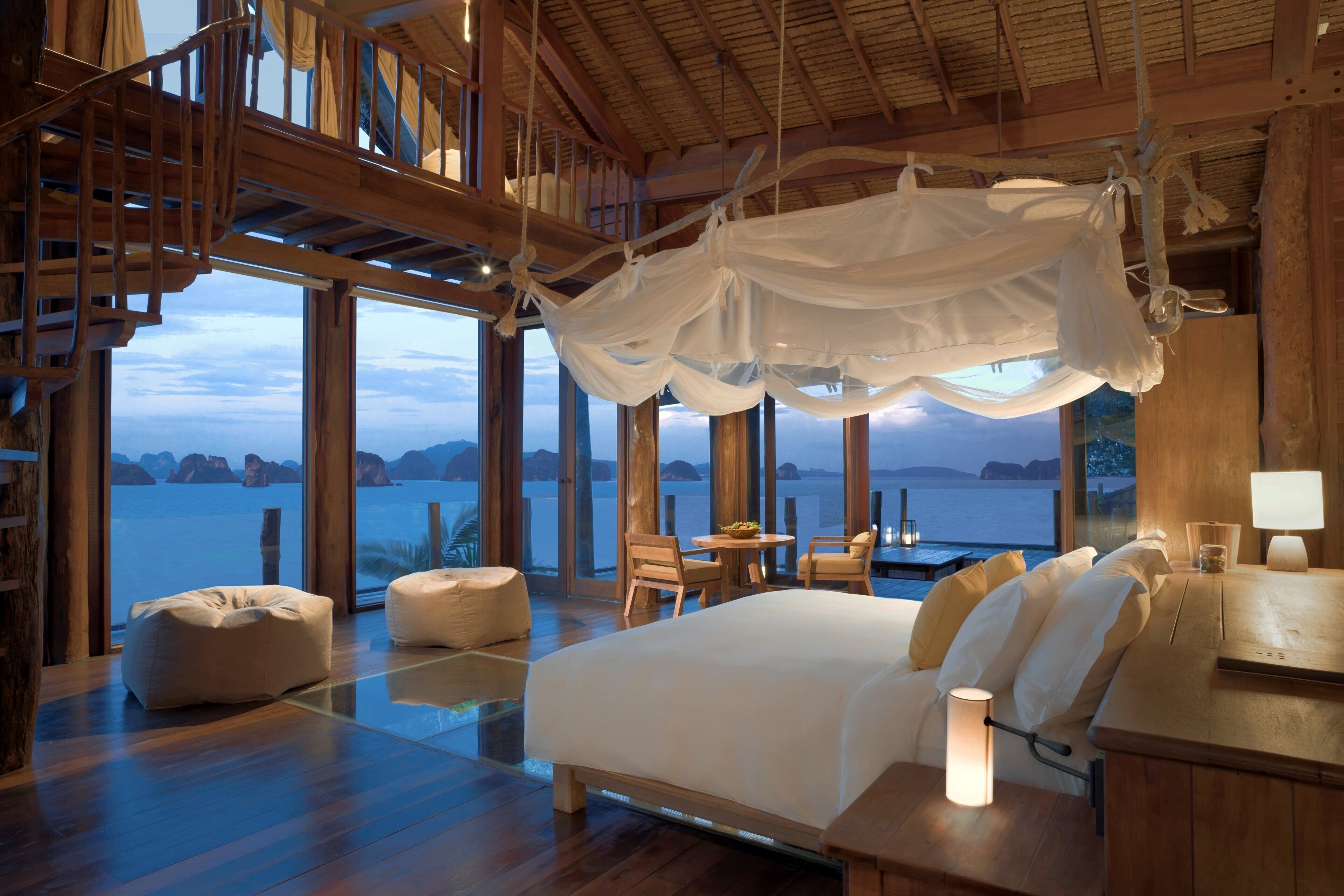 Ein geräumiges Schlafzimmer mit einem großen Bett, Holzboden und Meerblick.