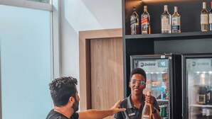 A bar area with a counter, seating, and a refrigerator stocked with beverages. - ibis Rio de Janeiro Centro (Rio de Janeiro)