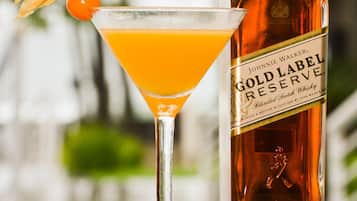 En flaske Johnnie Walker Gold Label Reserve whisky og et martiniglas med appelsinpynt.