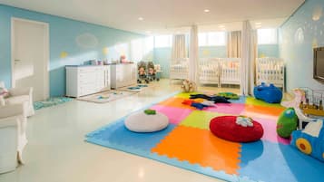 Children can play and relax in this spacious room with cribs, playpen, and plenty of toys.