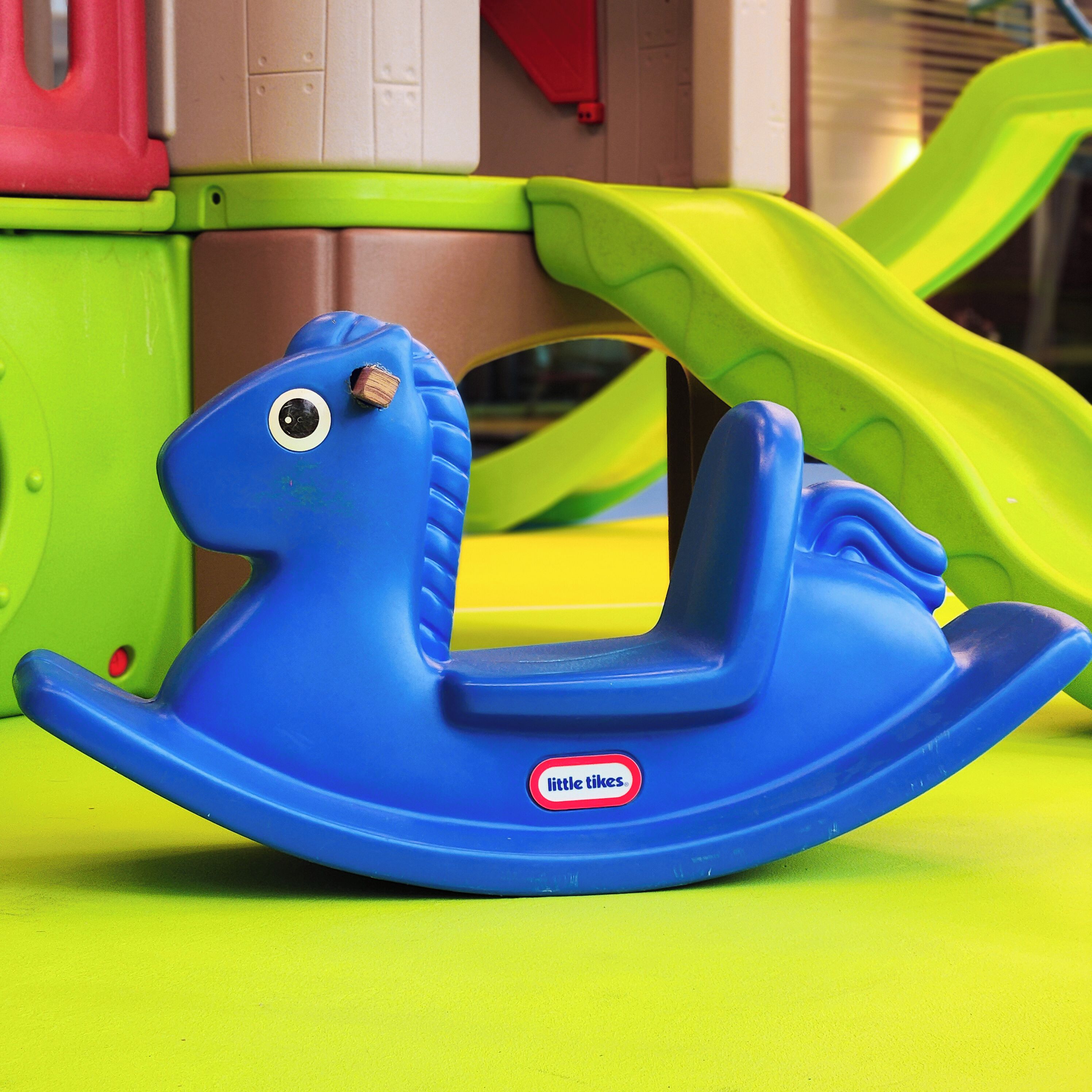 A blue rocking horse with a sticker that reads "little tikes."