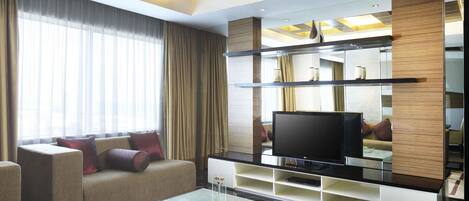Una sala de estar moderna con un televisor de pantalla plana, asientos cómodos y una mesa de centro de vidrio.