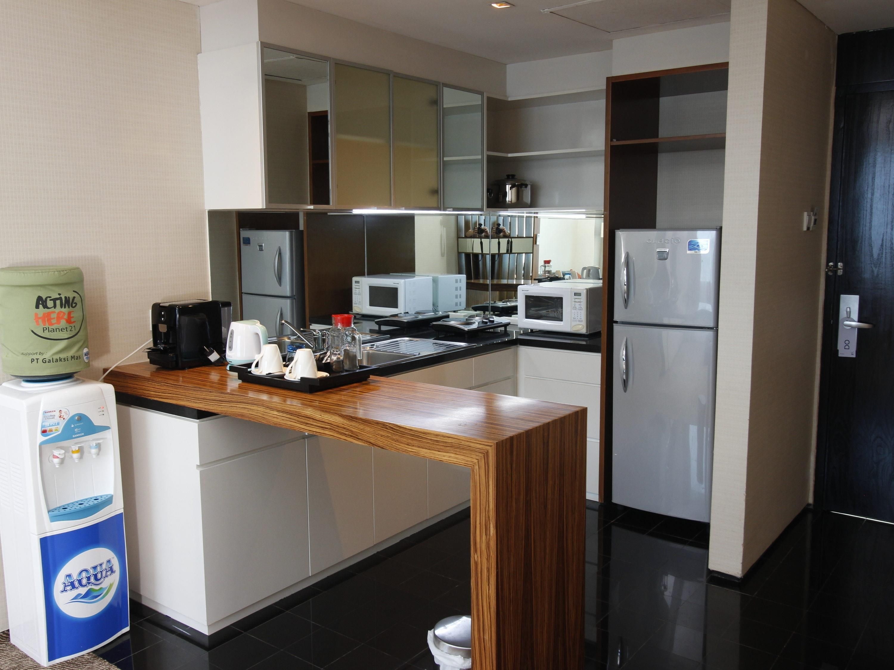 A modern kitchen with a wooden countertop, stainless steel appliances, and a water dispenser.