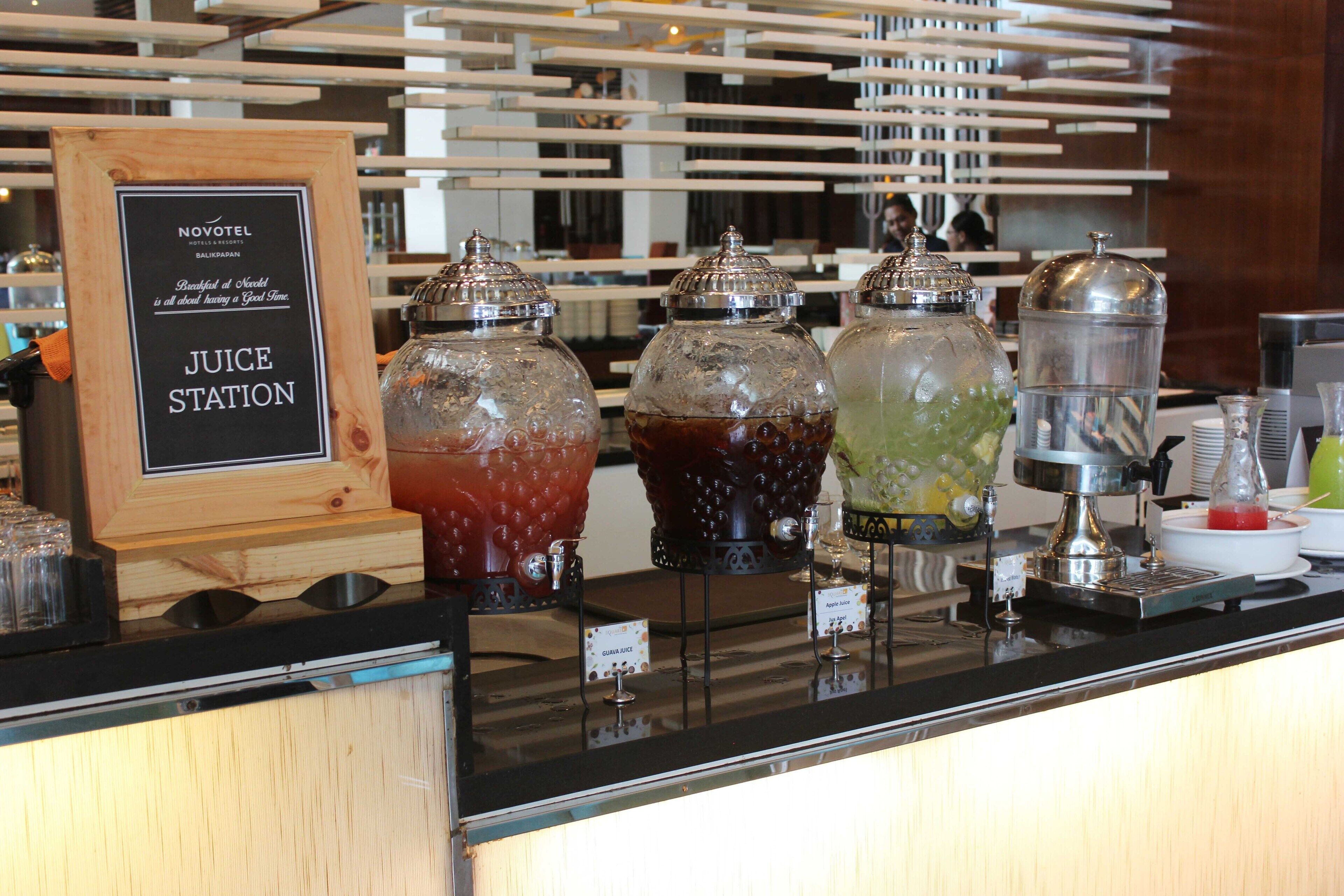 En juicebar med olika sorters drycker i glasflaskor på ett hotell.