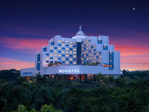 Un hotel con diseño moderno, con varios pisos y un llamativo letrero de 'Novotel'.