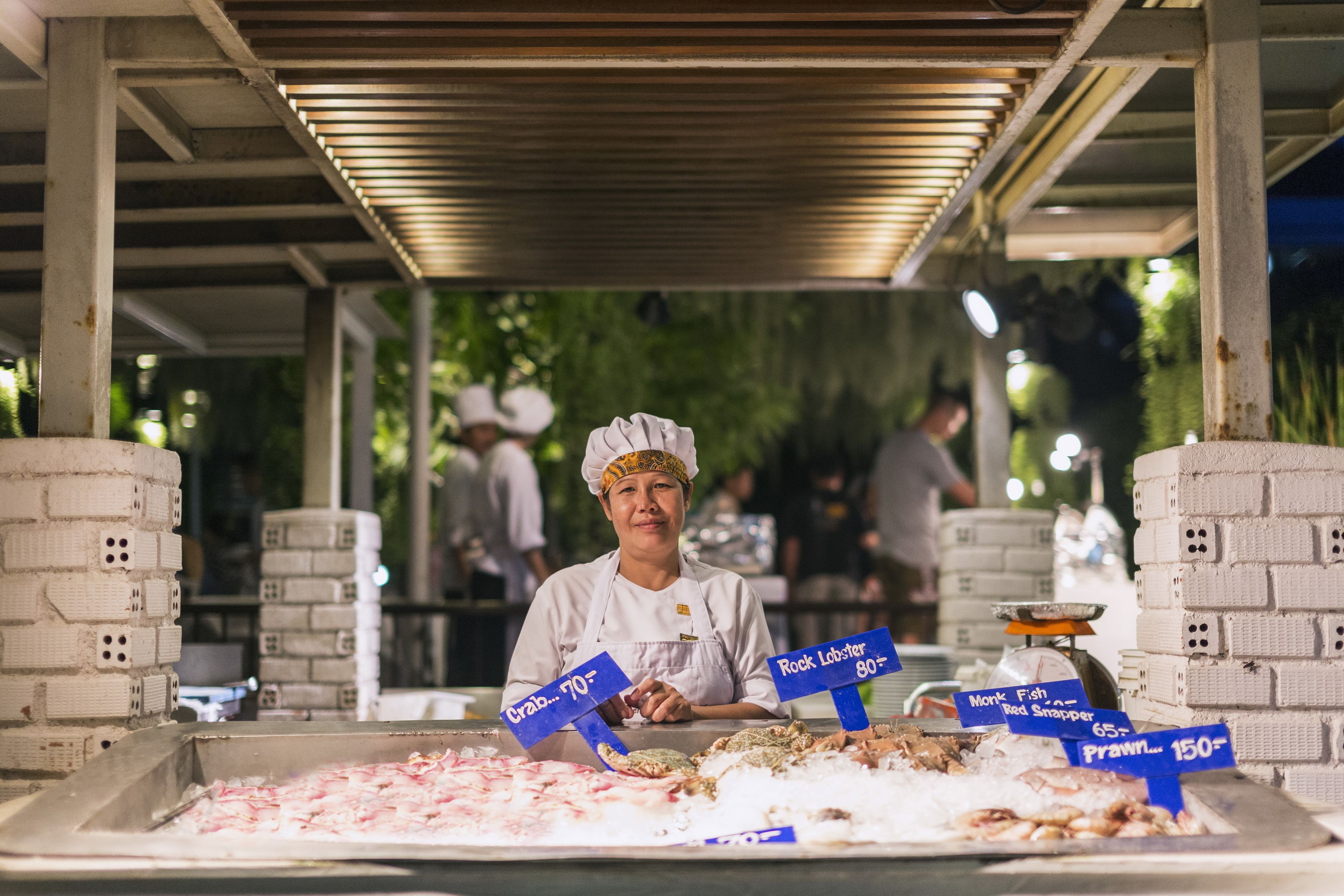 A seafood display with various types of fish and seafood, including crab, lobster, monk fish, and prawns, with price tags.