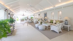 A spacious, well-lit lobby with white furniture, a dining area, and a view of the outdoors. - Kantary Bay Hotel, Phuket (Wichit)