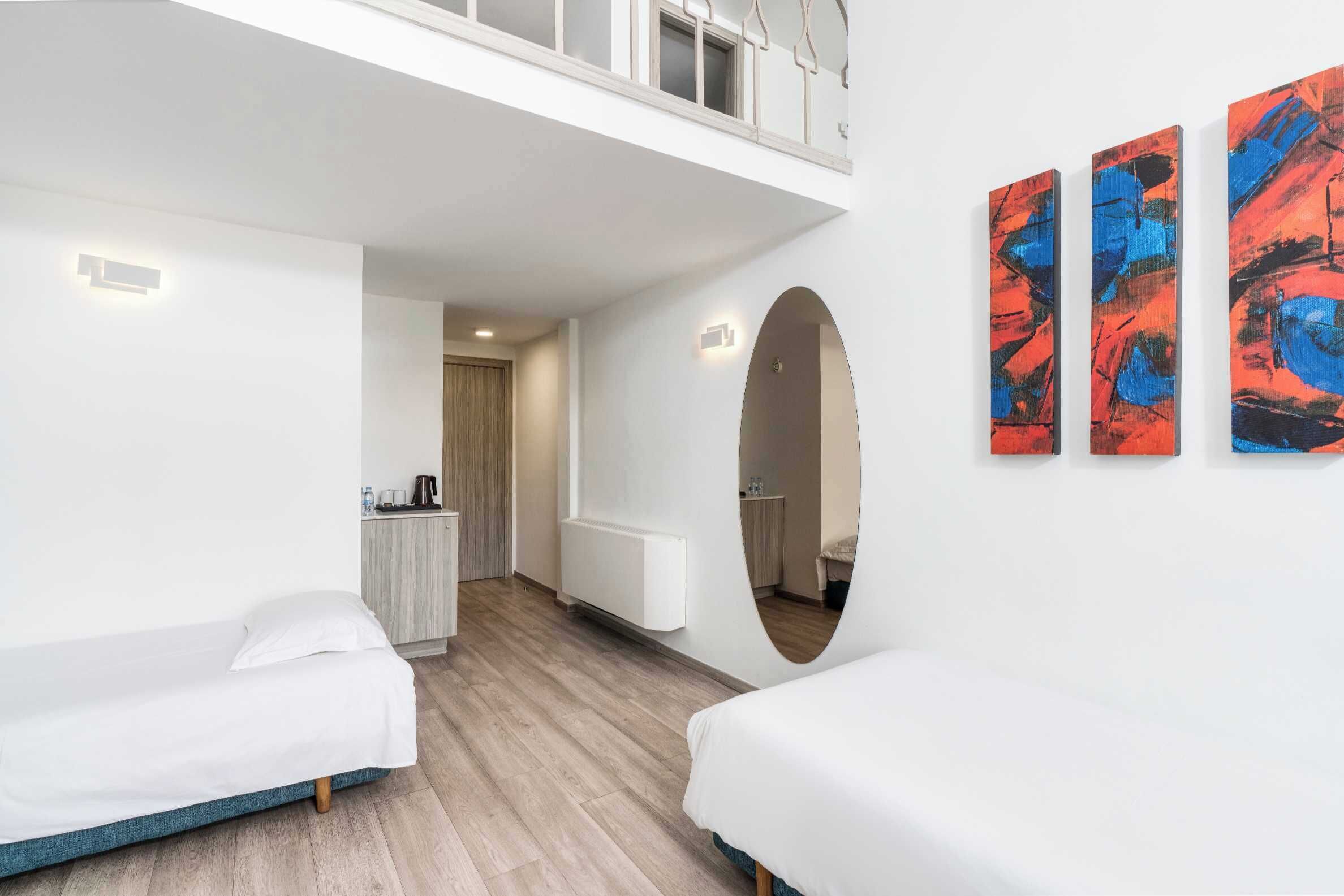 Habitación de hotel moderna con zona superior, cama, escritorio y vistas a la ciudad.