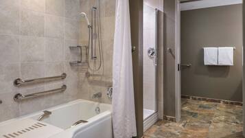 Un baño con bañera, ducha y cabina de ducha.