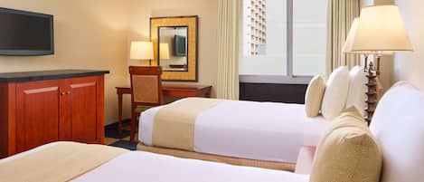 Une chambre d’hôtel avec deux lits, un bureau, une chaise, une télévision et une fenêtre avec des rideaux.