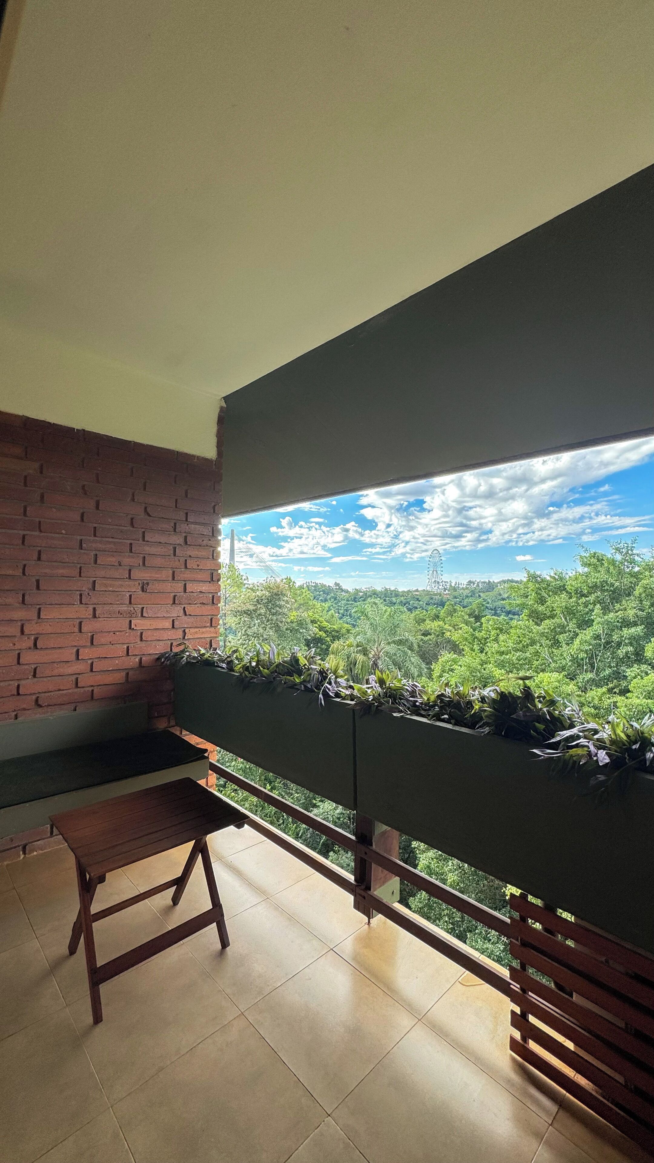 Un balcón con vista a un paisaje verde exuberante y un cielo despejado.
