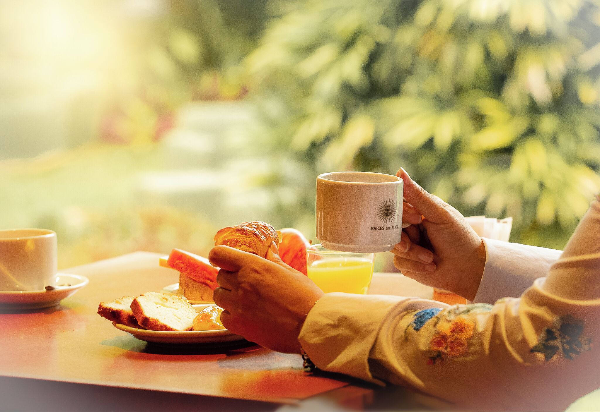 Ein Frühstückstisch mit Toast, Croissant, einer Kaffeetasse und einem Glas Orangensaft.
