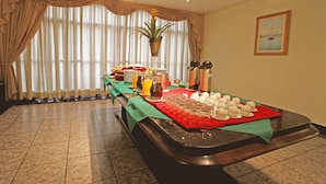 Un espace repas avec un buffet, comprenant des assiettes, des verres et une variété de plats.