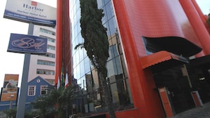 Un hôtel moderne, avec une façade rouge imposante et une grande section de fenêtres en verre.