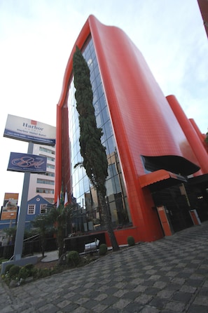 A modern hotel building with a prominent red facade and a large glass window section. - Blue Tree Towers Batel Curitiba (Curitiba)