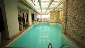 An indoor swimming pool with a stone wall on one side and a ceiling with skylights. - Mabu Curitiba Business (Curitiba)