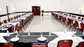 A conference room with round tables, red chairs, and white tablecloths. - Caravelle Palace Hotel (Curitiba)