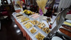 A buffet table with various food items and utensils. - Caravelle Palace Hotel (Curitiba)
