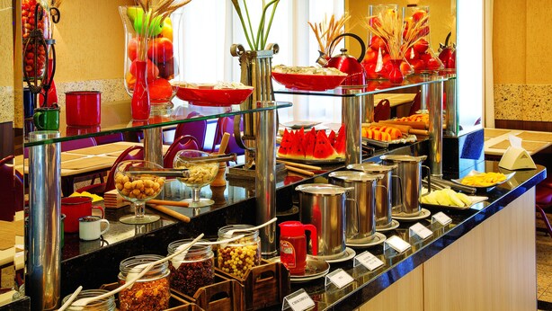 A buffet with various food items and utensils. - Lira Hotel (Curitiba)