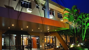 A hotel entrance with a modern design, glass doors, and a staircase leading to the lobby. - Lira Hotel (Curitiba)