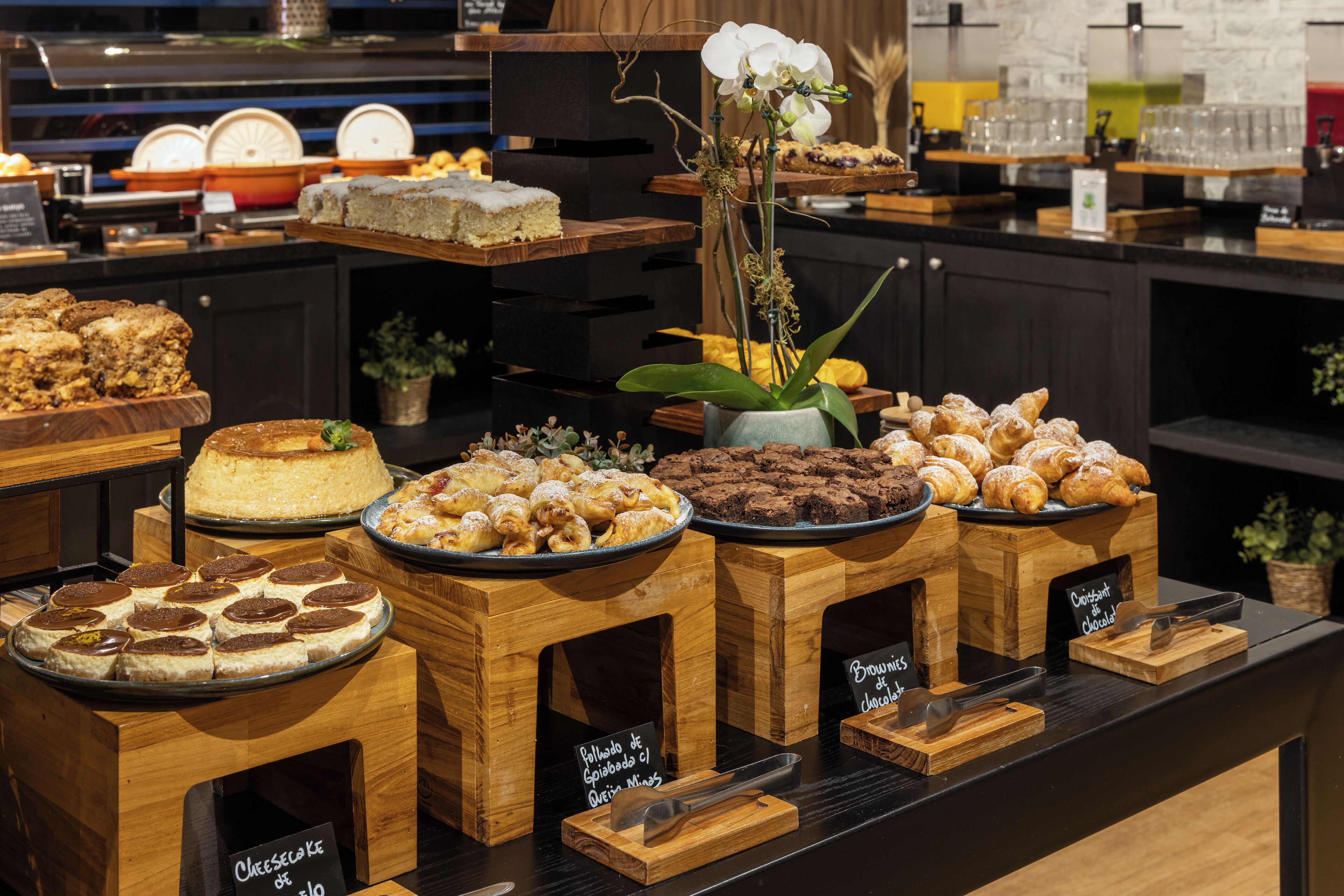 A buffet with various desserts including cakes, pastries, and chocolate items.