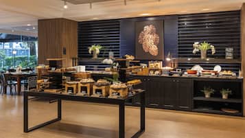A buffet area with various food items and a wooden table in the foreground.
