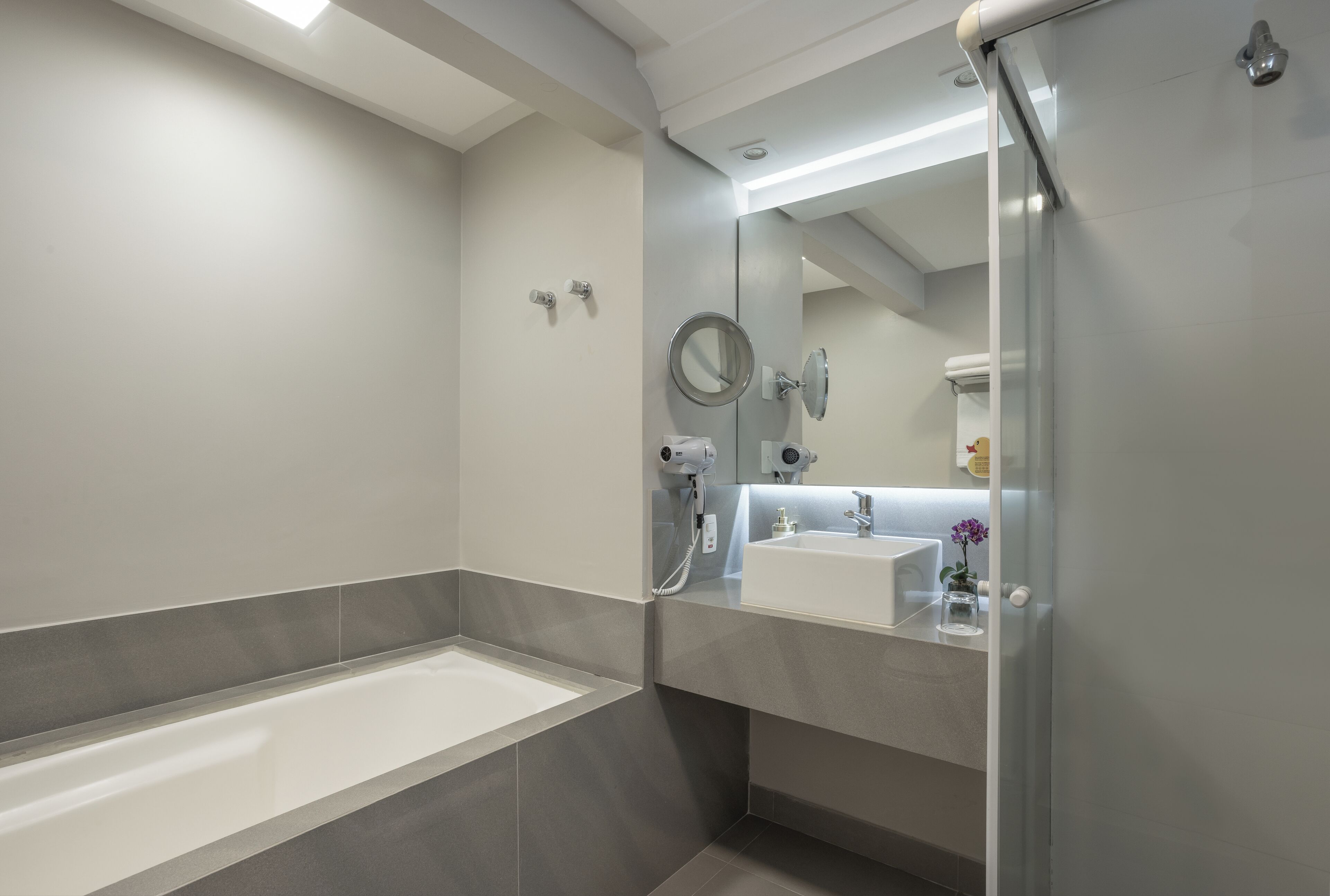 Un baño moderno con bañera, lavamanos y ducha.