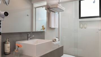 Un bagno moderno con un lavandino ampio, un water e una cabina doccia in vetro.
