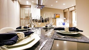 A dining table set with plates, cutlery, and wine glasses, with a modern interior and a view of the room. - Hotel Ingleses Holiday (Florianopolis)