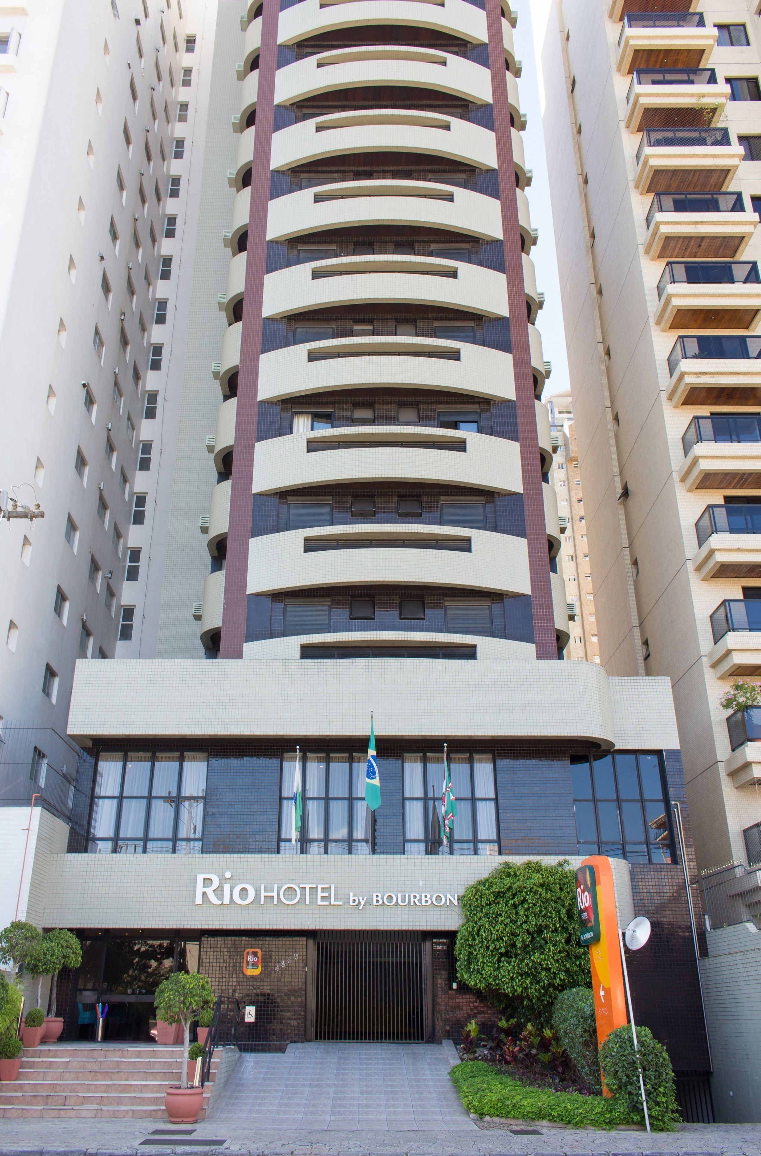 Un edificio de hotel alto con varios balcones y un letrero que dice "Rio Hotel by Bourbon".