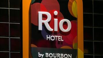 A hotel sign with the name "Rio Hotel by Bourbon" and "Curitiba Batel" visible.