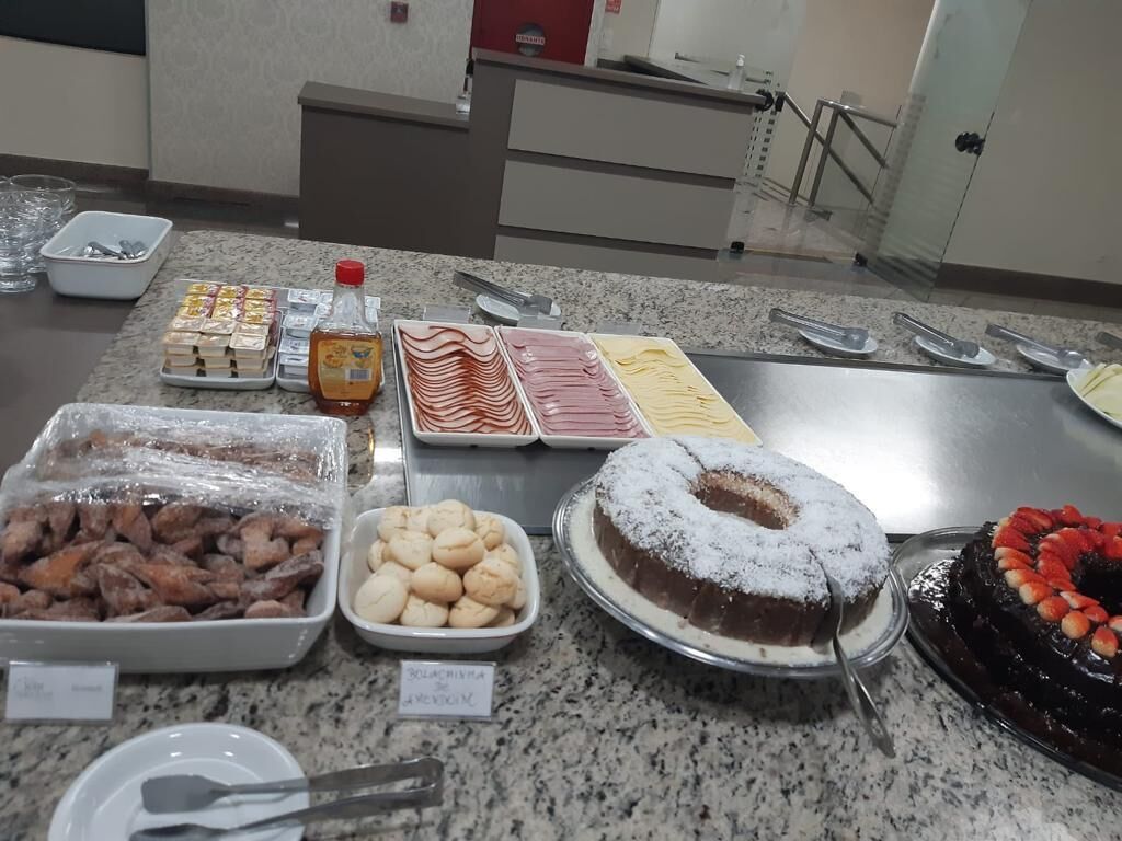 Een buffet met diverse gerechten, waaronder gebak, een chocoladetaart en een chocoladedessert met aardbeien.