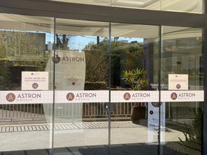L’entrée d’un hôtel, avec des portes en verre et de nombreux panneaux publicitaires présentant l’hôtel et ses différents services.