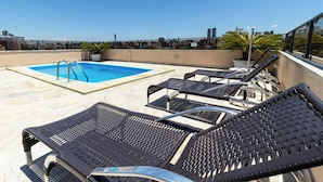 Une piscine située sur le toit, offrant une vue dégagée sur le paysage urbain, notamment les gratte-ciel.