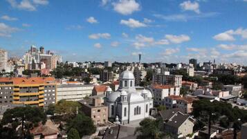 A cityscape with a prominent white church with a dome and bell tower, surrounded by residential buildings and a clear blue sky.