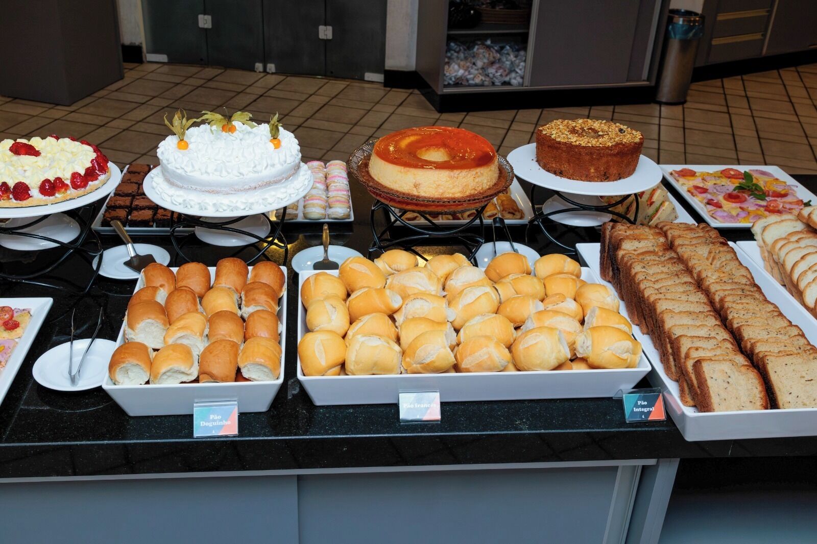 Un buffet con diverse pietanze, tra cui torte, pasticcini e pane.