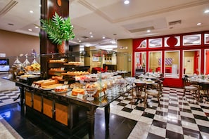 A buffet with various food items and a checkered floor. - Transamerica Executive Curitiba Batel (Curitiba)
