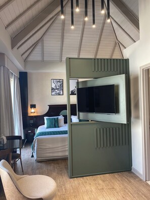Una habitación de hotel moderna con una cama, un televisor, un escritorio y una silla.