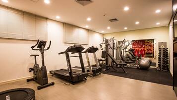 A gym with treadmills, elliptical machines, and weight equipment.