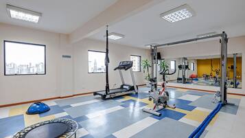 Ein Fitnessraum mit Laufband, Ergometer und Trampolin.