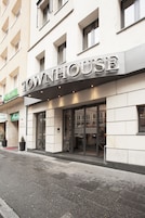 Un edificio con un cartello che riporta la scritta "TOWNHOUSE" e un ingresso ben visibile.