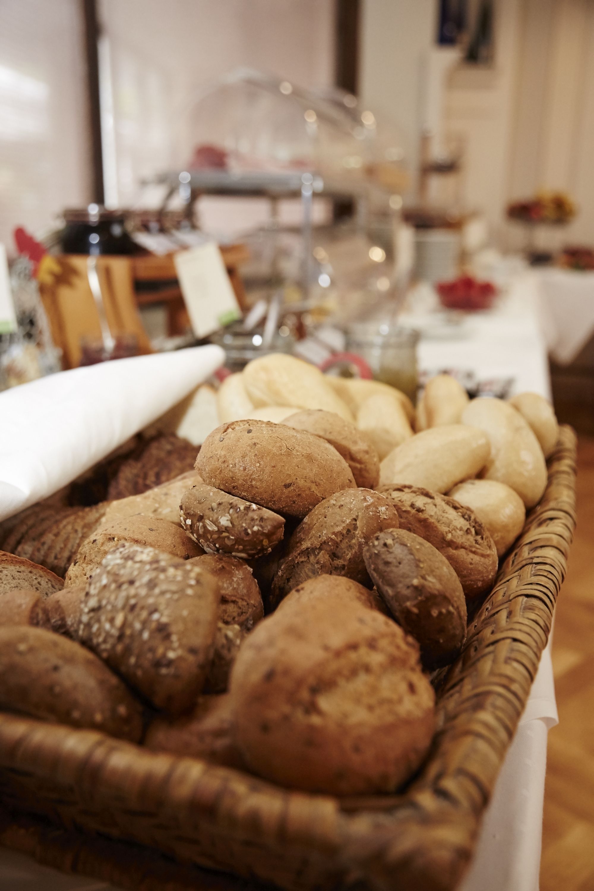 Eine Auswahl an Brot in einer Korb auf einem Tisch.