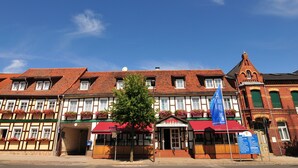 A traditional European hotel with a red awning, multiple windows, and a flag. - Flair Hotel Deutsches Haus (Arendsee)