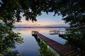 Eine Holzstege, der sich über ruhiges Wasser erstreckt, umgeben von Bäumen.