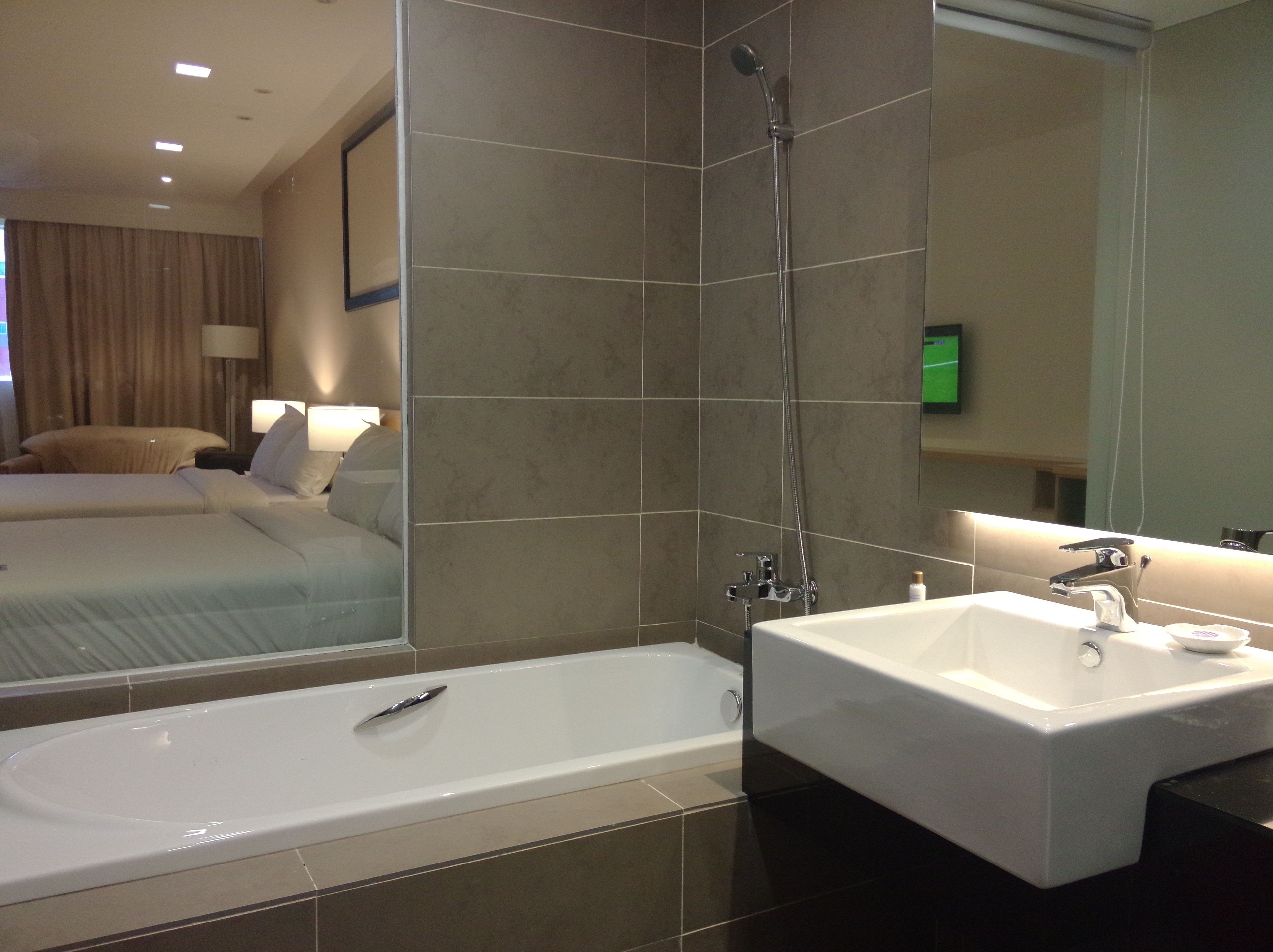 A modern bathroom with a bathtub, a shower, and a sink.