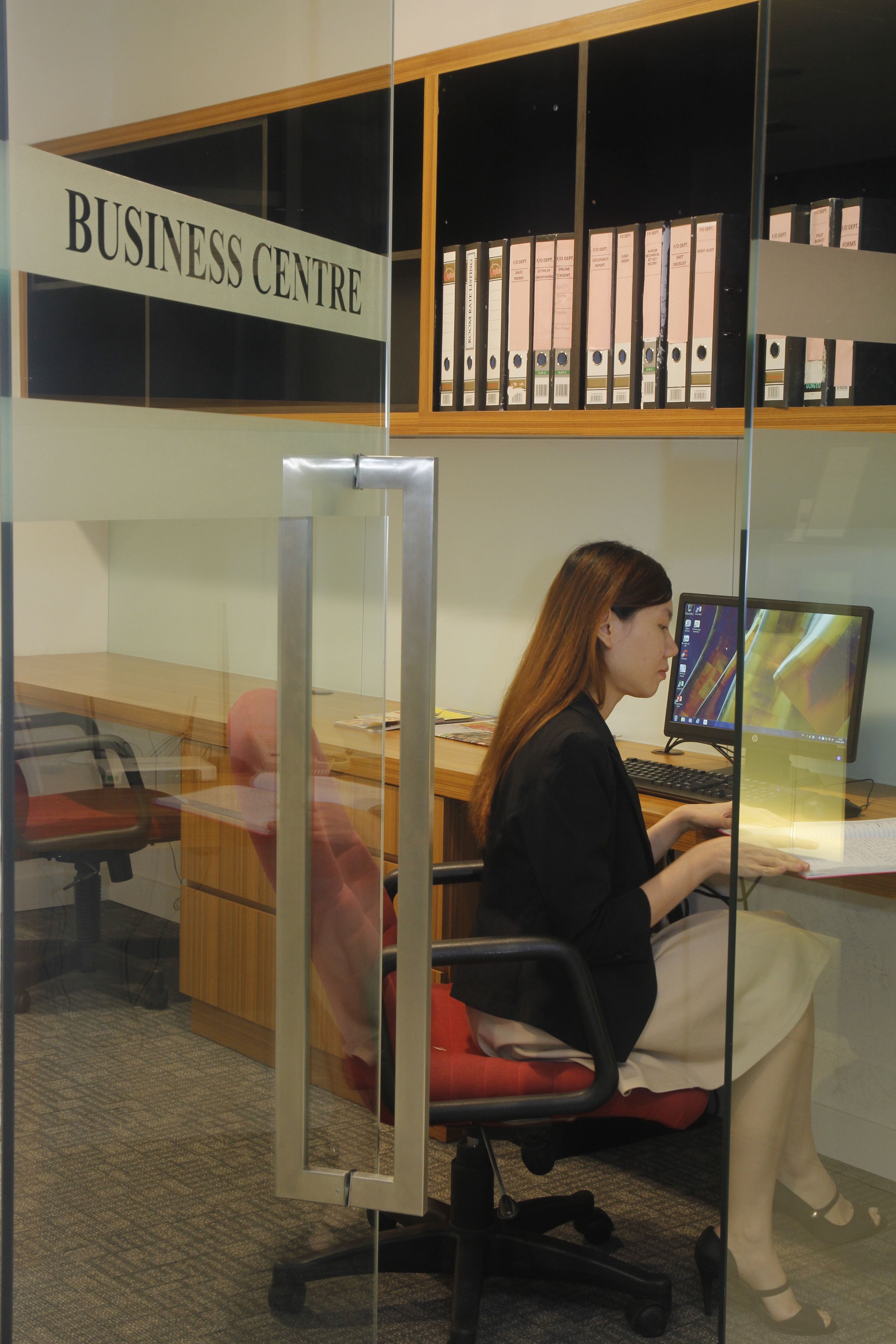 Un centre d’affaires équipé d’un bureau avec ordinateur, d’une chaise et d’un mannequin.