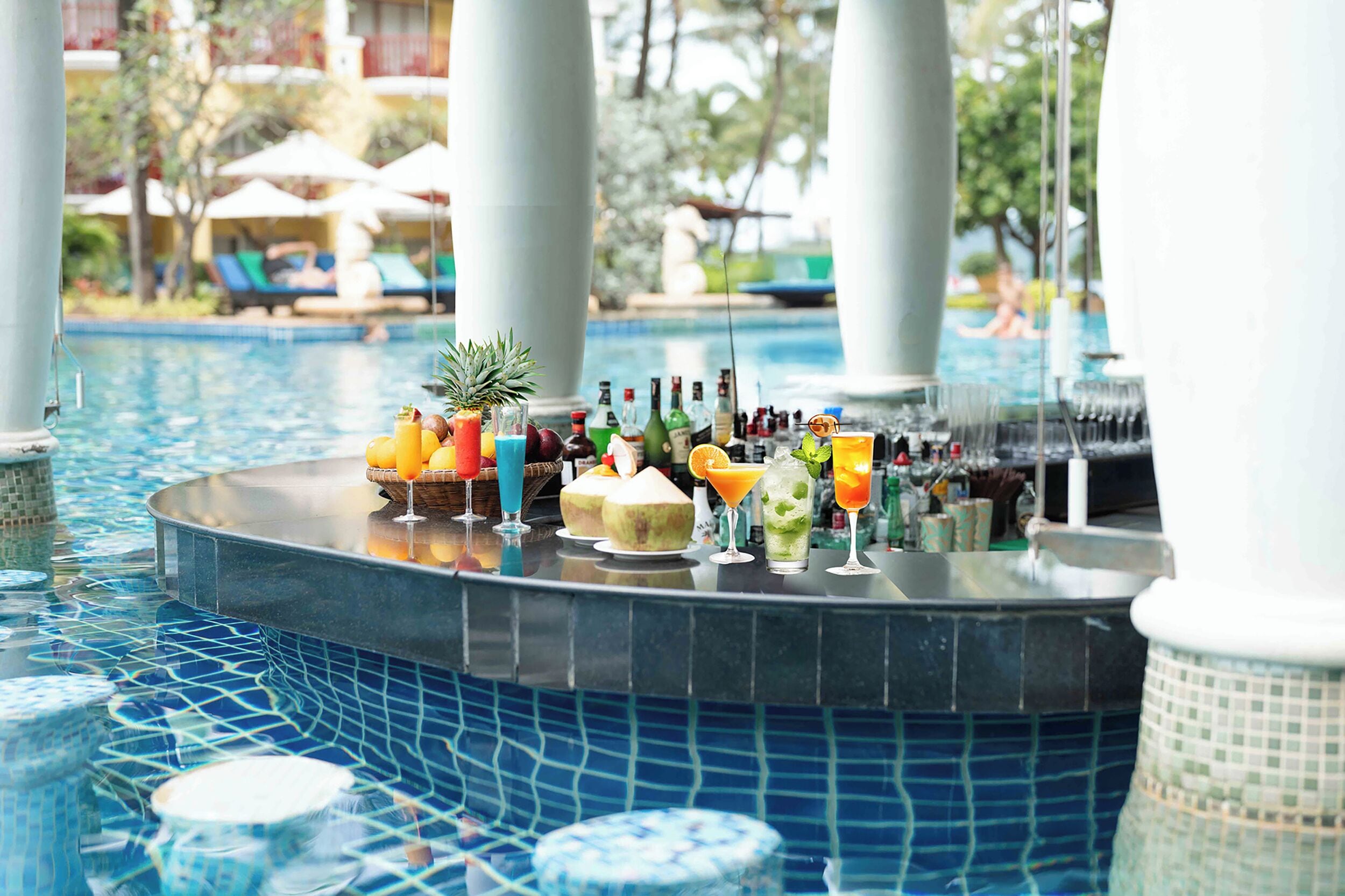 Un bar junto a la piscina con diversas bebidas y una piña.